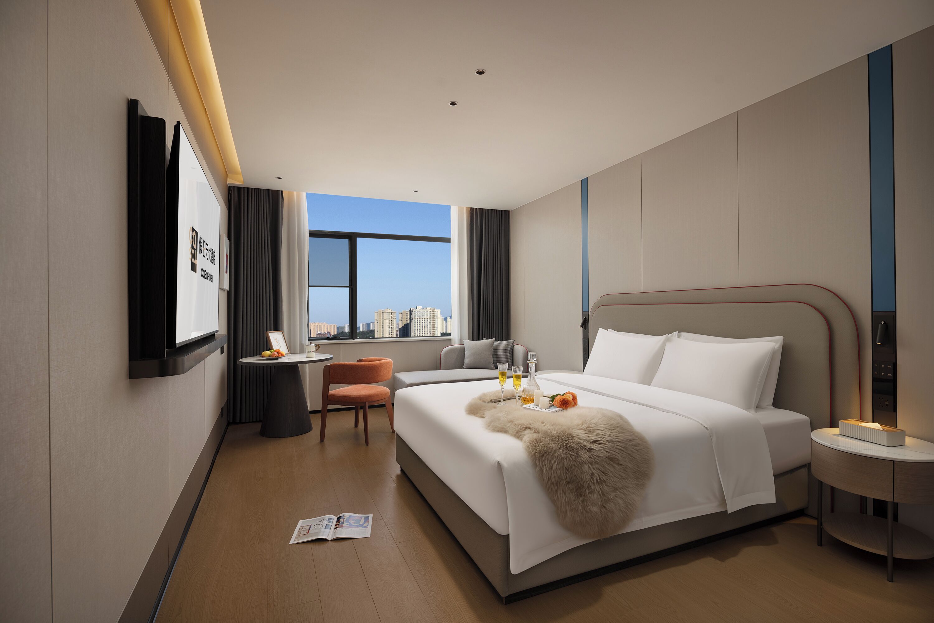 Una habitación de hotel moderna con una cama grande, un escritorio y vistas a la ciudad.