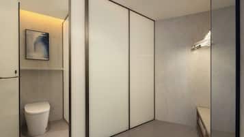 A modern bathroom with a toilet, a shower area, and a wall-mounted light fixture.