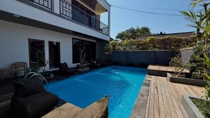 A modern two-story house with a swimming pool, outdoor seating, and a balcony. - Skyline Sanur (Denpasar)