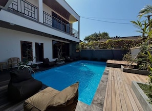 A modern two-story house with a swimming pool, outdoor seating, and a balcony. - Skyline Sanur (Denpasar)
