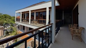 A multi-level balcony with outdoor furniture, a clear view of the surrounding area, and a modern architectural design. - Skyline Sanur (Denpasar)