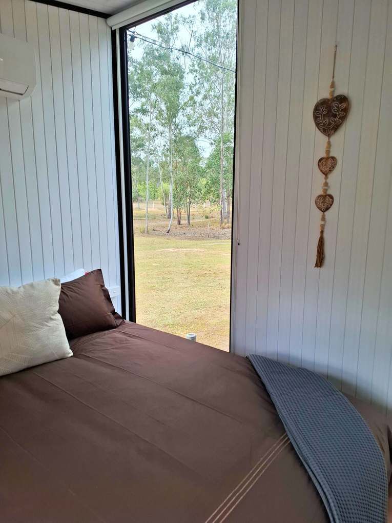 Une chambre à coucher avec un lit, une fenêtre et une vue sur l’extérieur.