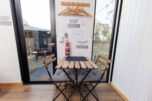 A wooden table with grey cushions and a fire extinguisher mounted on the wall.