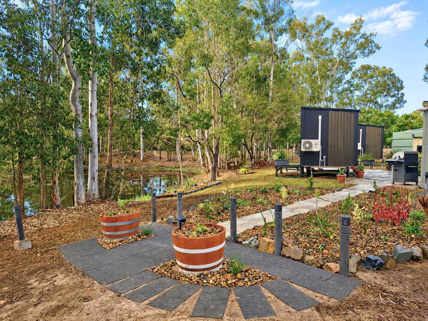 A landscaped outdoor area with a pathway, potted plants, and a water feature.