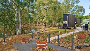 A landscaped outdoor area with a pathway, potted plants, and a water feature.