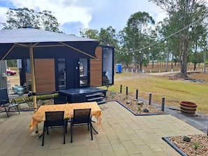 Un espace extérieur aménagé avec une structure couverte, des tables et des chaises.