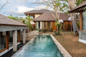 Une propriété résidentielle dotée d’une piscine, de murs en pierre et d’une maison en bois avec un toit en tuiles.