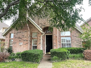 A brick house with a black front door, a small porch, and a mailbox. - Gated Valley Ranch Stay, Near DFW Airport & More (Irving)