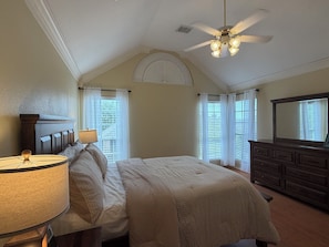 A bedroom with a bed, a dresser, a ceiling fan, and a window with curtains. - Gated Valley Ranch Stay, Near DFW Airport & More (Irving)