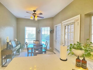 A dining area with a ceiling fan, a table with chairs, and a view through the windows. - Gated Valley Ranch Stay, Near DFW Airport & More (Irving)