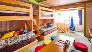 Ein Zimmer mit Etagenbetten, einer Schlafcouch, einem Tisch und einem Hängesessel.