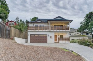 A two-story house with a garage, a balcony, and a driveway.