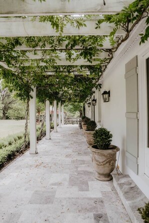 A covered walkway with a series of planters and a lamp post.