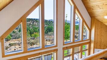 Una habitación con ventanas amplias que ofrecen vistas a un paisaje montañoso.