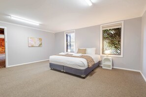 A bedroom with a bed, a nightstand, a window with a view, and a door leading to another room. - The Shire Retreat, Dubbo (Dubbo)