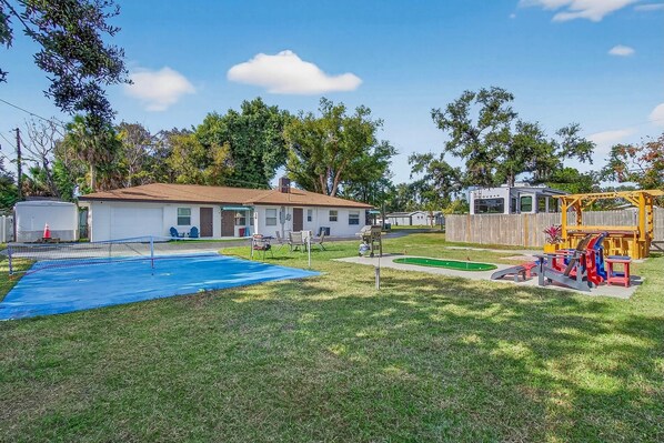 Un cortile residenziale con piscina, area giochi e un'abitazione mobile.