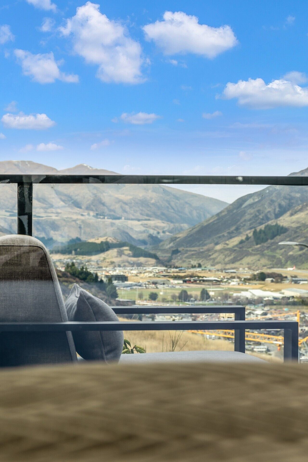 Une vue depuis un balcon, avec un paysage montagneux et une chaise.