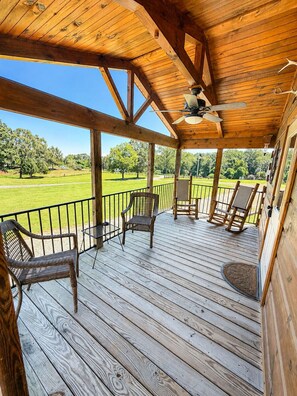 A wooden deck with outdoor seating and a ceiling fan. - Cozy Cabin - 3 mins from TIEC (Tryon)