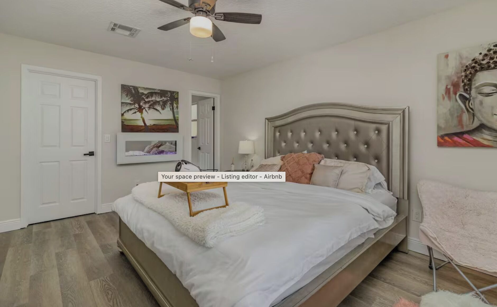 Ein Schlafzimmer mit Bett, Deckenventilator, Tür und Wandbildern.