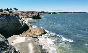 Paisagem costeira com linha de costa rochosa e águas azul-claras.