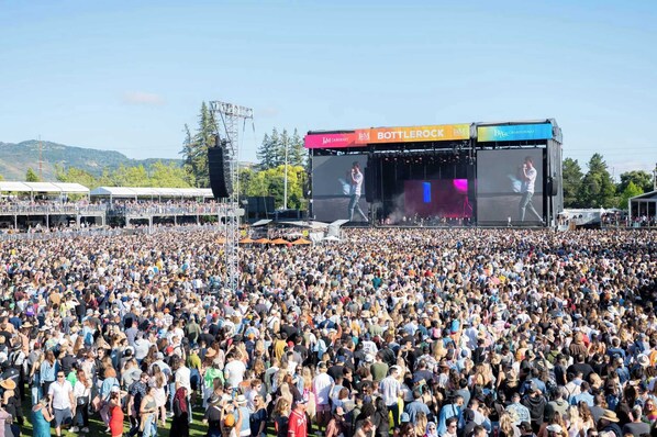 Um grande concerto ao ar livre com palco e público.