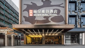 Entrada de un hotel con un cartel grande que muestra el nombre 'REZEN DONG HOTEL'.