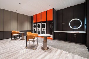 Una habitación moderna con zona de estar, tocador y un espejo.