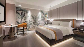 Une chambre d’hôtel moderne avec un grand lit, un bureau et une chaise.