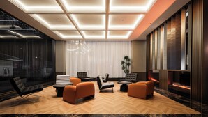 Un intérieur moderne avec un parquet disposé en chevrons, une cheminée et un coin salon comprenant des canapés et une table basse.