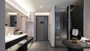Une salle de bain moderne avec un grand miroir, un meuble-lavabo et une douche séparée.