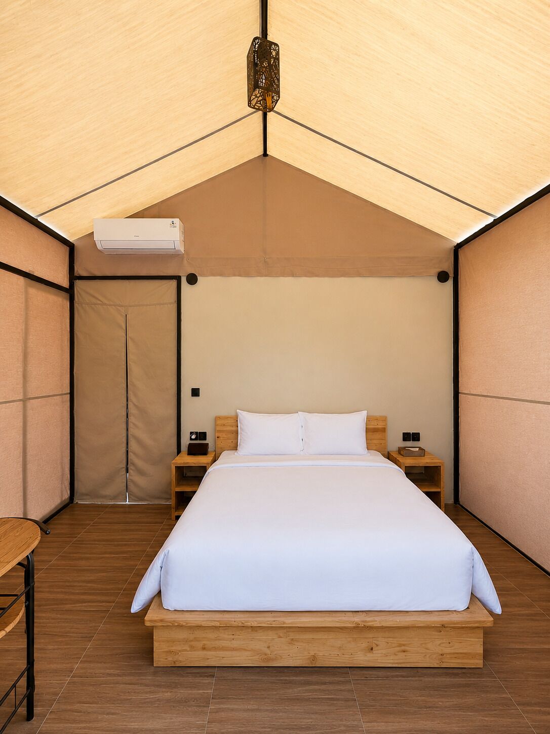 A tent-style room with a bed, bedside tables, and a hanging light fixture.