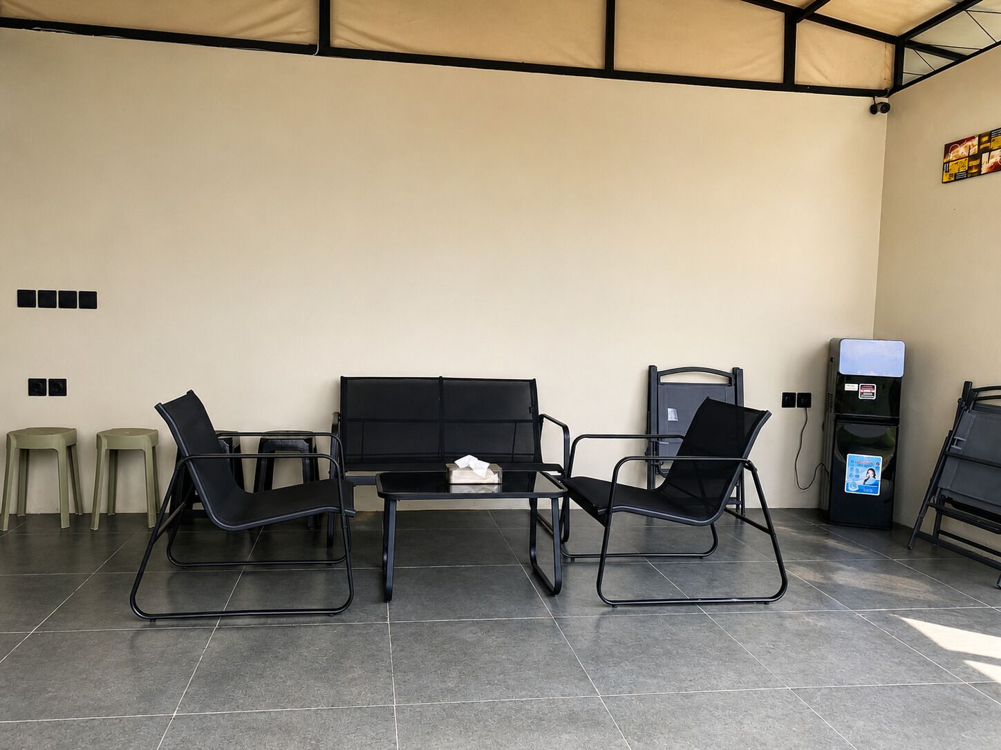 A seating area with a table and chairs, a water dispenser, and a trash bin.