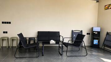 A seating area with a table and chairs, a water dispenser, and a trash bin.