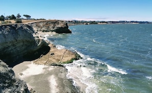 Paisagem costeira com linha de costa rochosa e águas azul-claras.