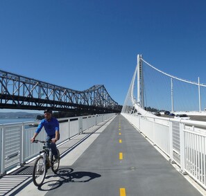 A person riding a bicycle on a bridge with a clear sky. - NEW Central 3BD Home 30 MIN to SF, Berkeley, Napa (Pinole)