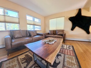 A modern living room with leather sofas, a wooden coffee table, and a large fur rug. - Awesome 3-bedroom apartment in Anchorage perfect for your getaway (Anchorage)