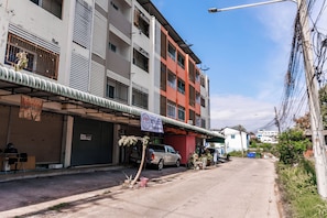 A multi-story building with a commercial ground floor, a parked pickup truck, and a clear sky.