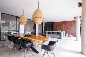 Ein zeitgemäßer Essbereich mit Holztisch, schwarzen Stühlen und einer Pendelleuchte.