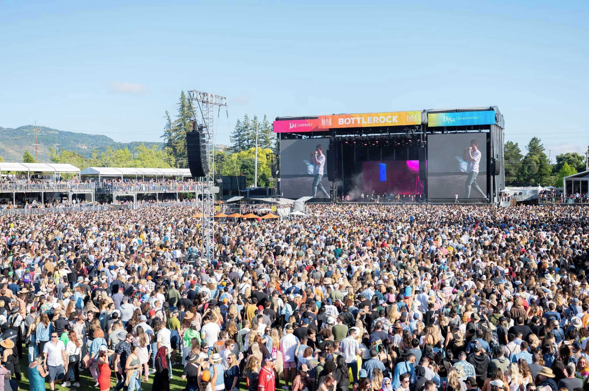 A large outdoor concert with a stage and a crowd.