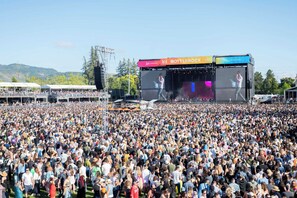 Um grande concerto ao ar livre com palco e público.