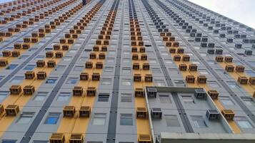 Een hoog gebouw met veel airconditioners en ramen.