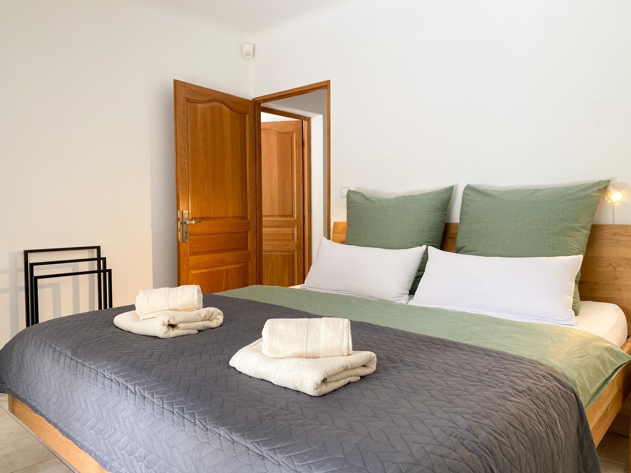 Un dormitorio con cama, almohadas y dos toallas.