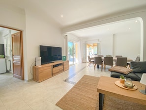A spacious living area with a television, wooden cabinet, dining table, and chairs. - Beautiful villa with pool and close to a village (Lorgues)