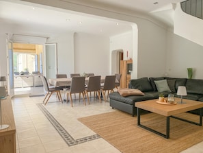 A modern living room with a sofa, coffee table, and dining area with chairs. - Beautiful villa with pool and close to a village (Lorgues)