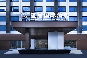 La entrada del Hotel Shengtai International, con una fachada moderna y un letrero visible sobre la puerta.