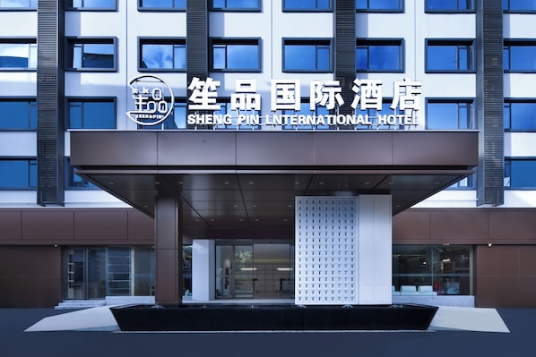 The entrance of the Shengtai International Hotel with a modern facade and a clear sign above the entrance.