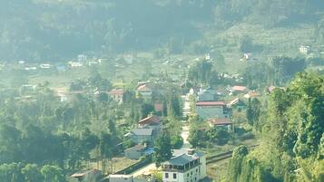 A rural village with houses and terraced fields, surrounded by hills.