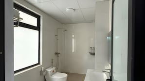 Un baño moderno con inodoro, bidé y lavamanos.