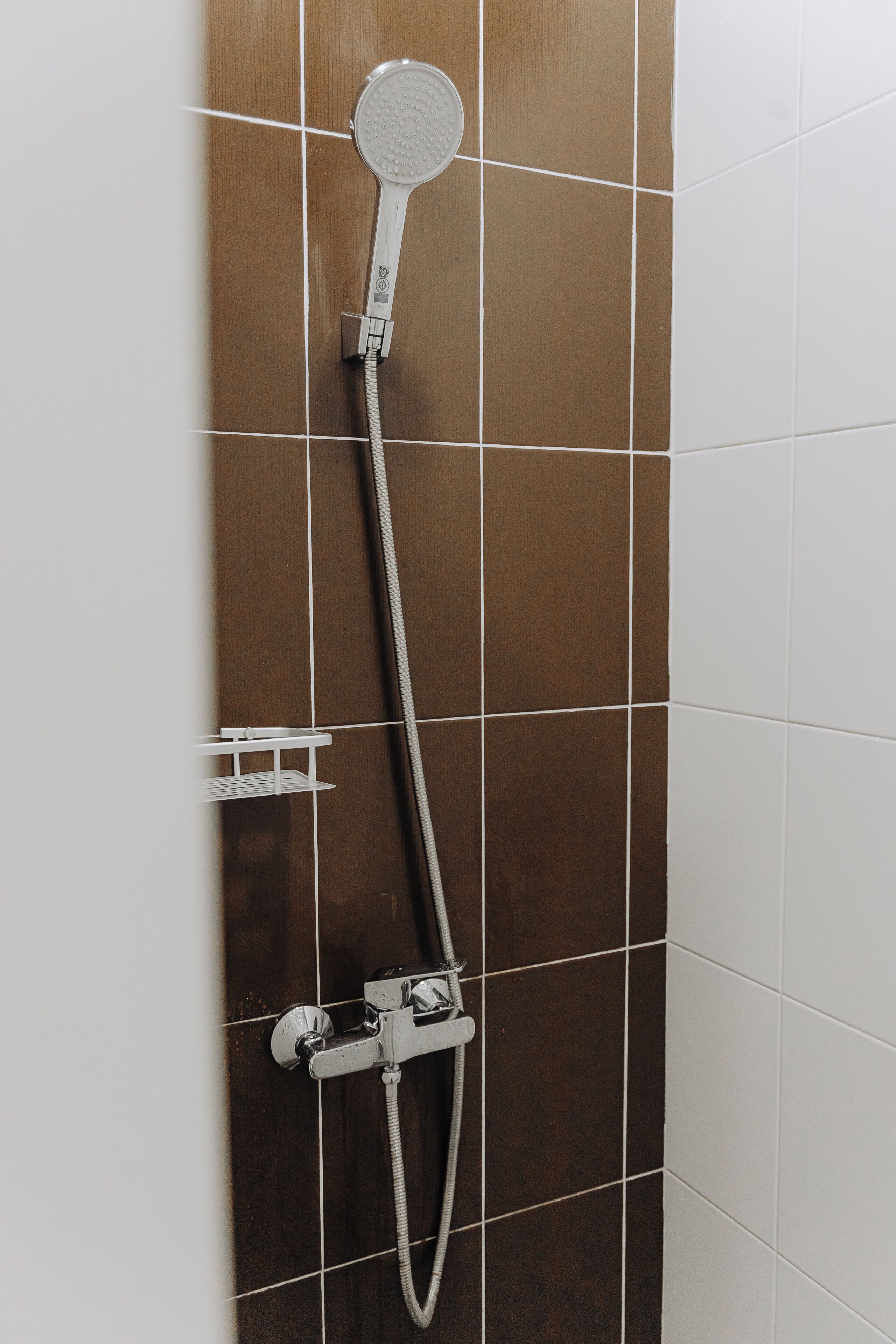 Eine Dusche mit Duschkopf und flexiblen Schlauch.