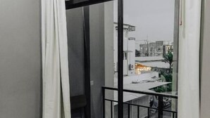A room with a sliding glass door leading to a balcony with a metal railing. - The One Rooms (Tambon Rawai)